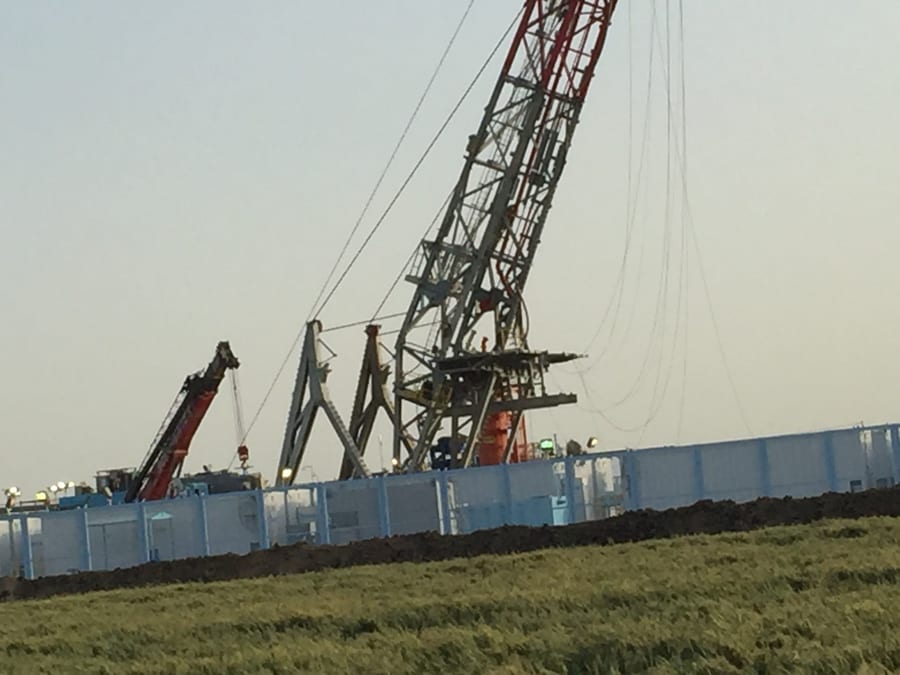 A drilling rig on a prepared location in farmland.